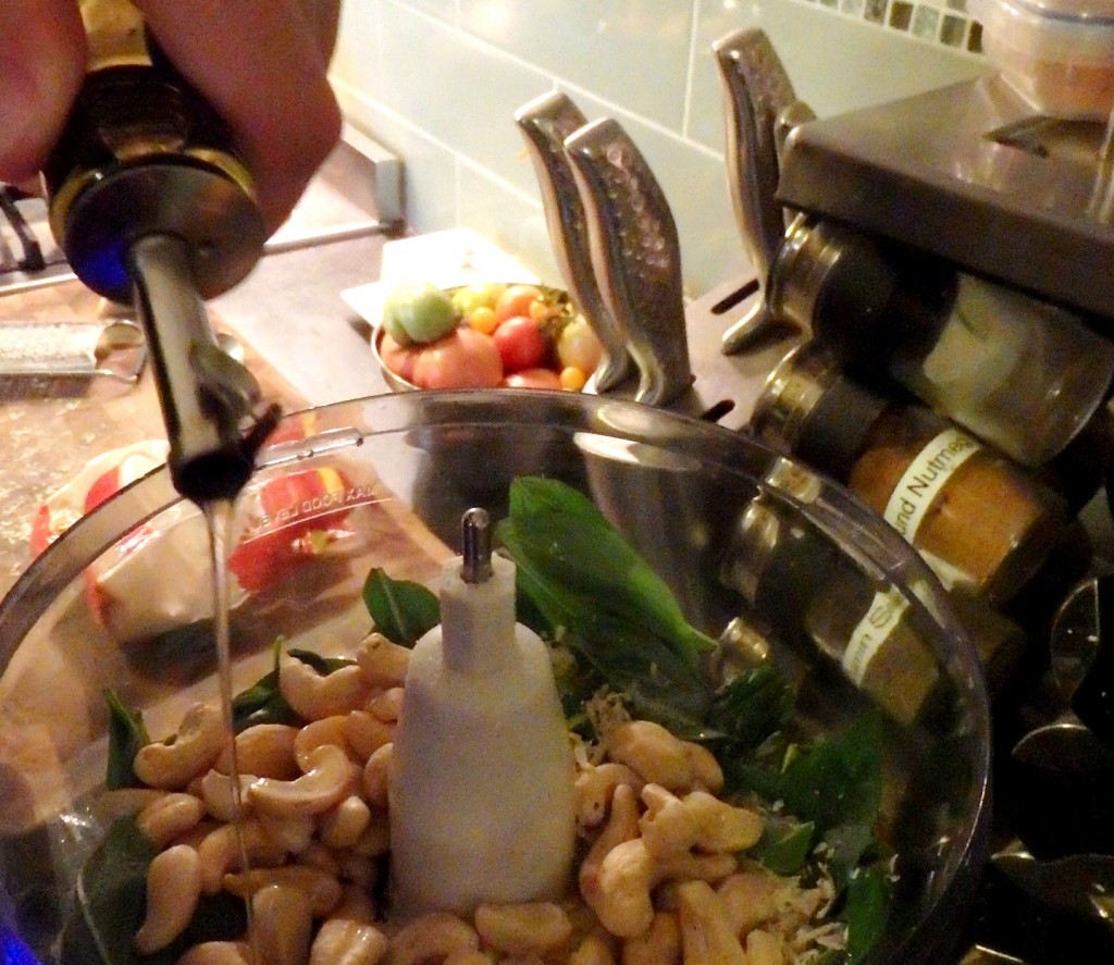 Adding cashew nuts and olive oil to make pesto